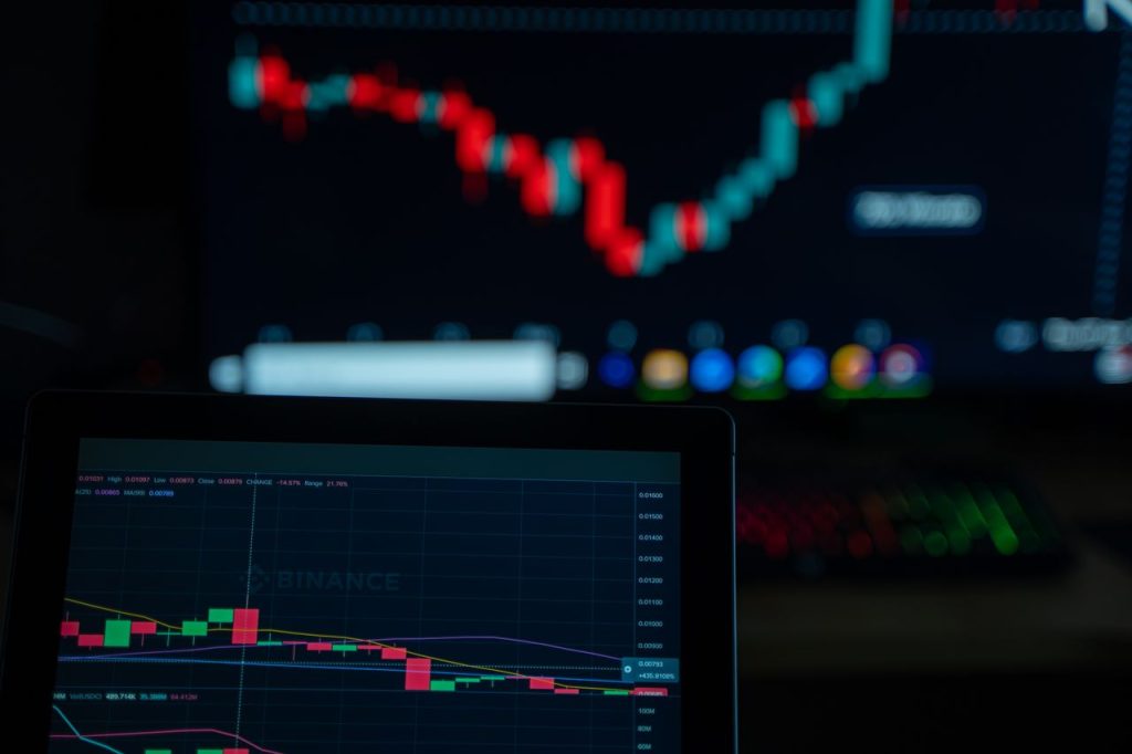 Close-up of cryptocurrency market charts on multiple screens showcasing trading data and trends.